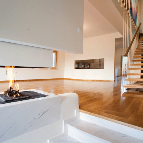 Passive house interior with fireplace and staircase in Agria by XG Group of Engineers